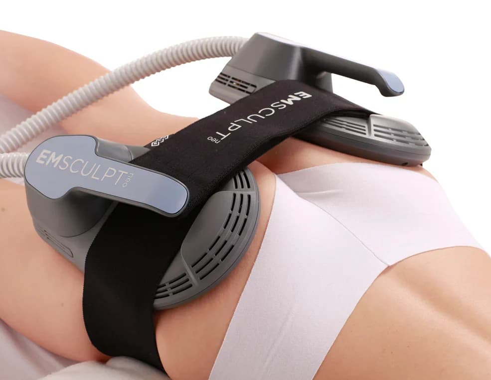 Emsculpt NEO applicators strapped across the abdomen during treatment